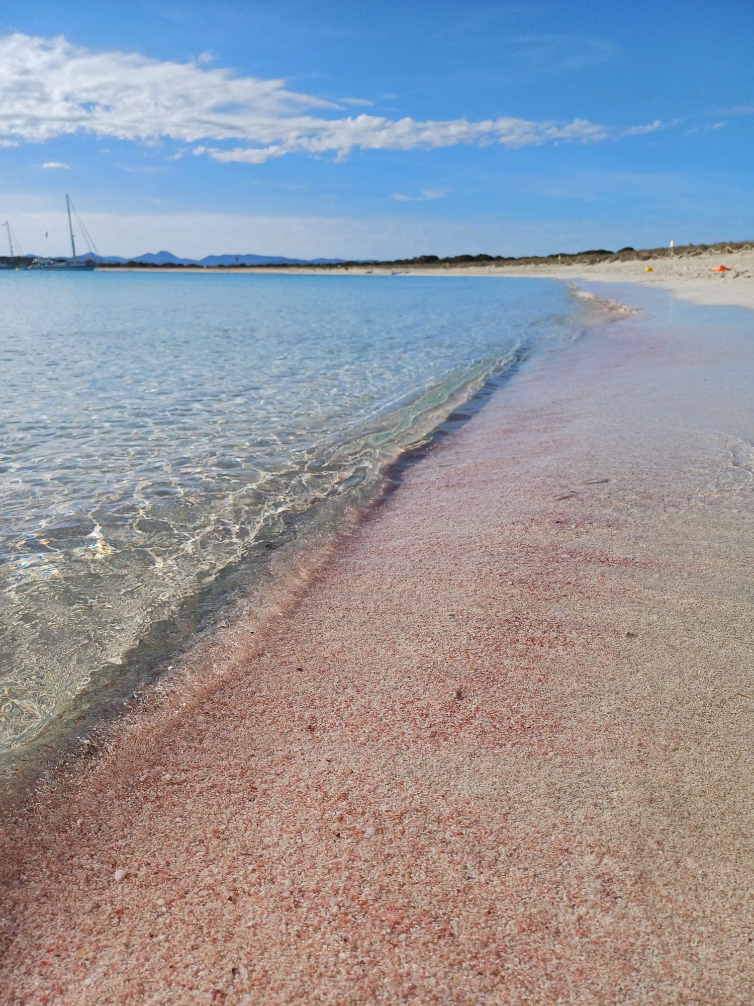 Pink sand and clear shallows on a Formentera beach