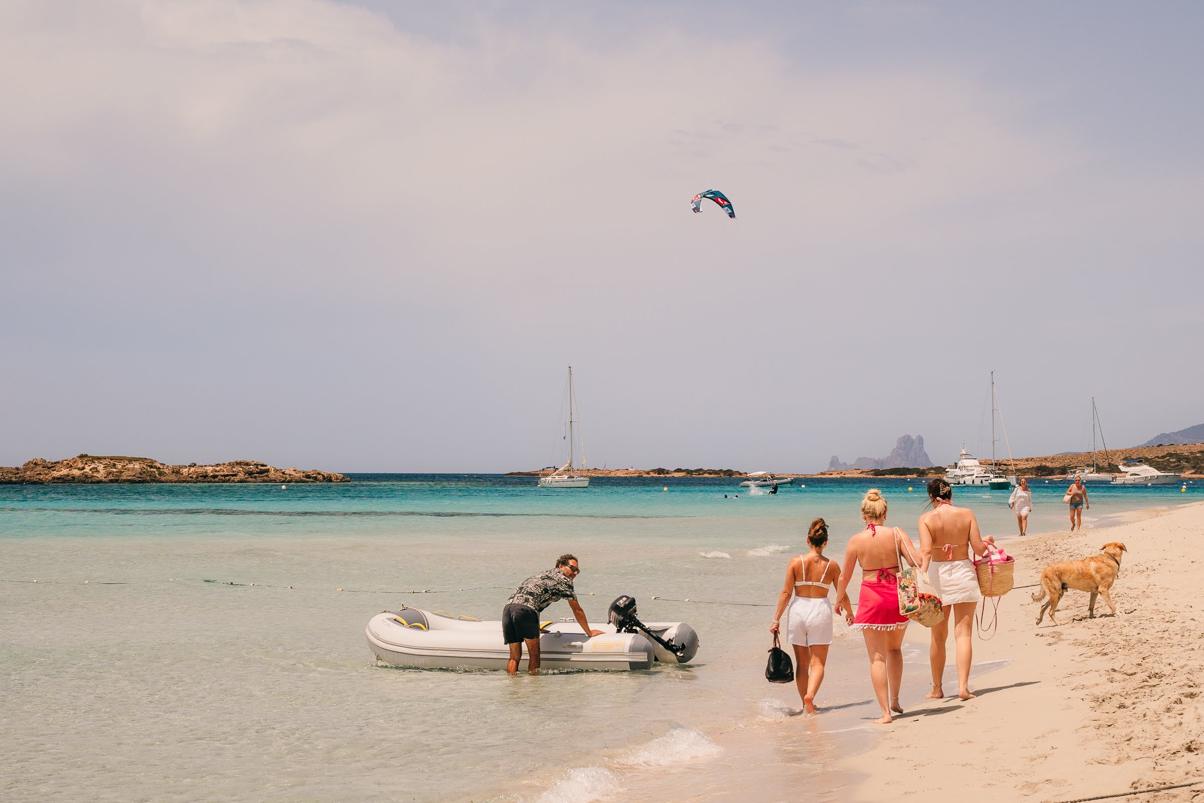 Guests coming ashore with the dinghy on a white Ibiza beach